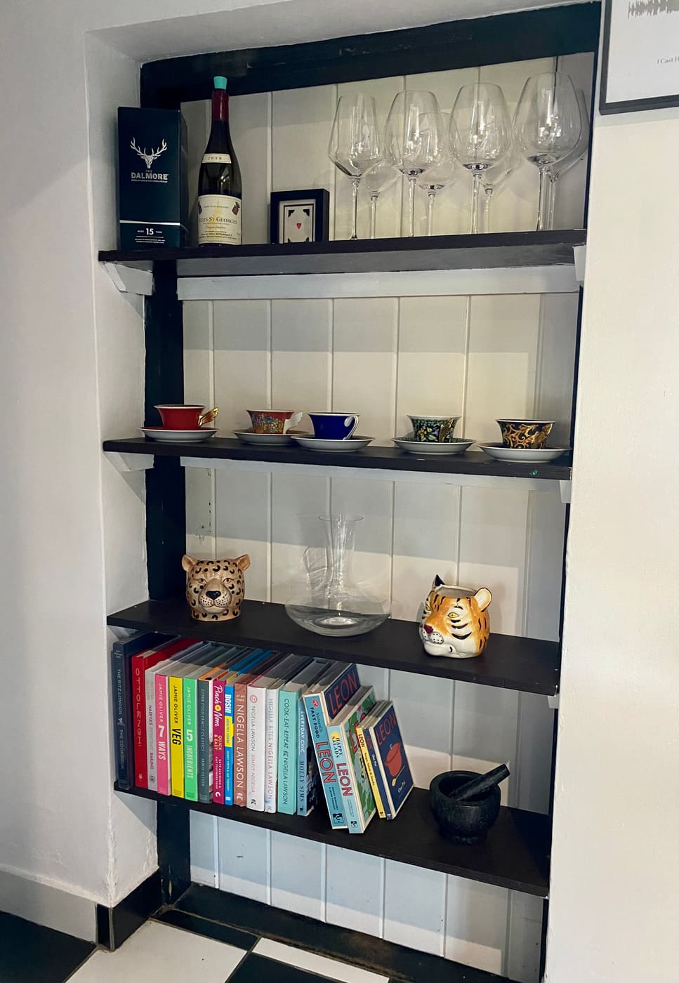 Styled alcove shelves with cookbooks and glassware